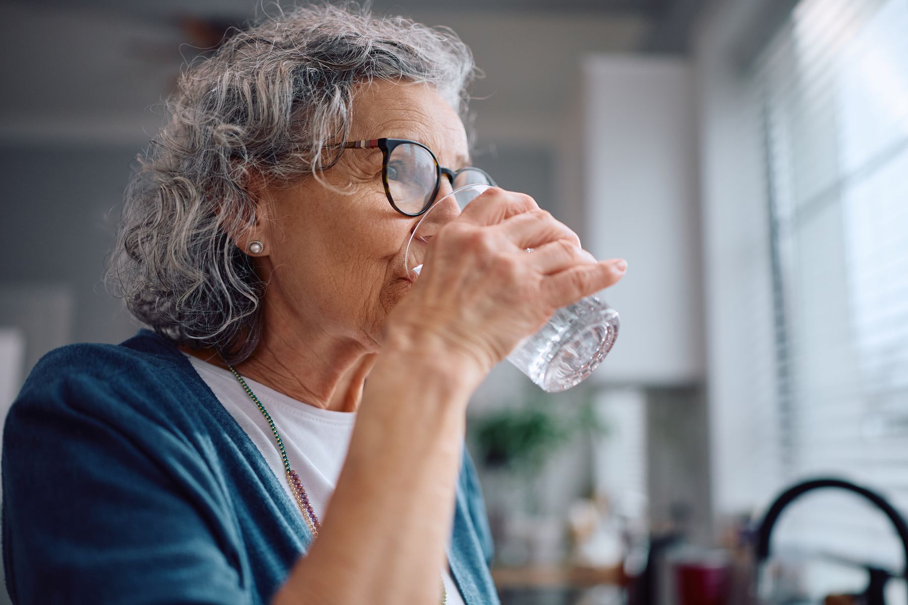 Senior qui boit pour limiter les risques d'escarres