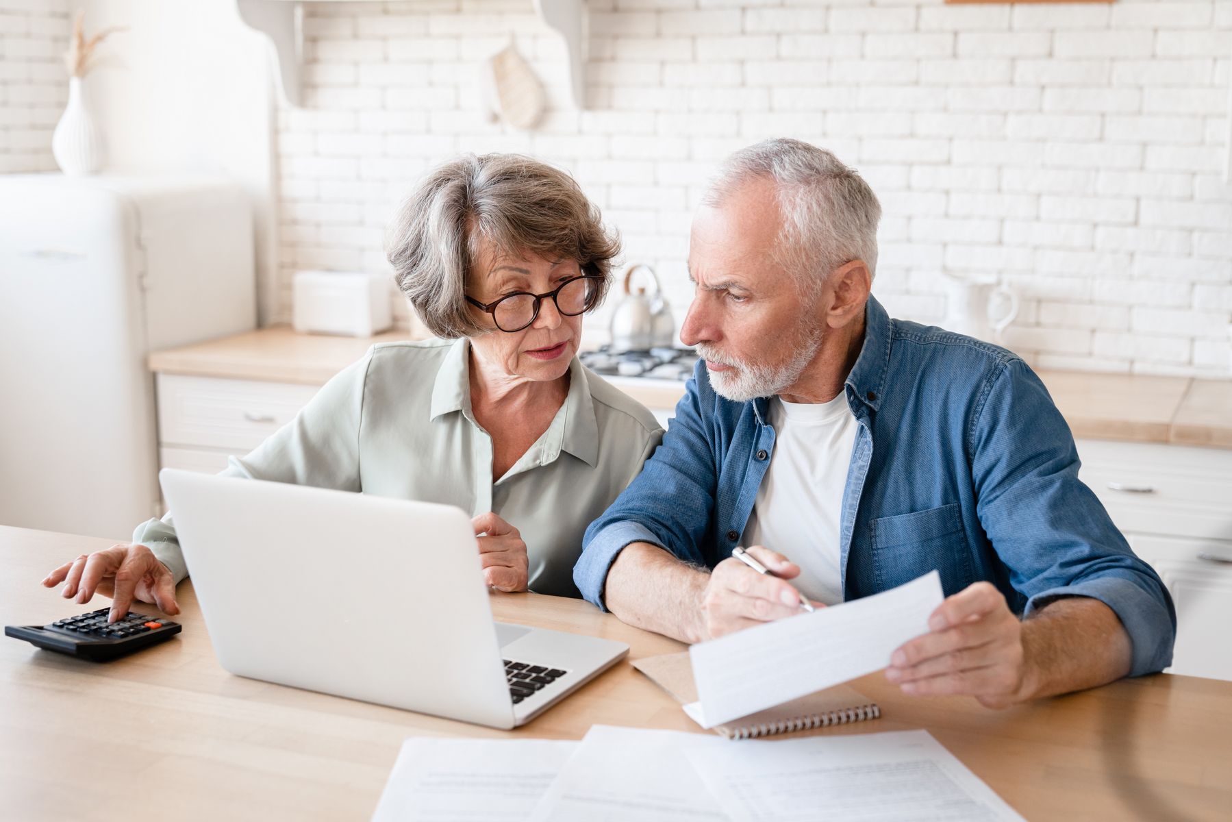 Seniors qui calculent le prix d'une maison de retraite