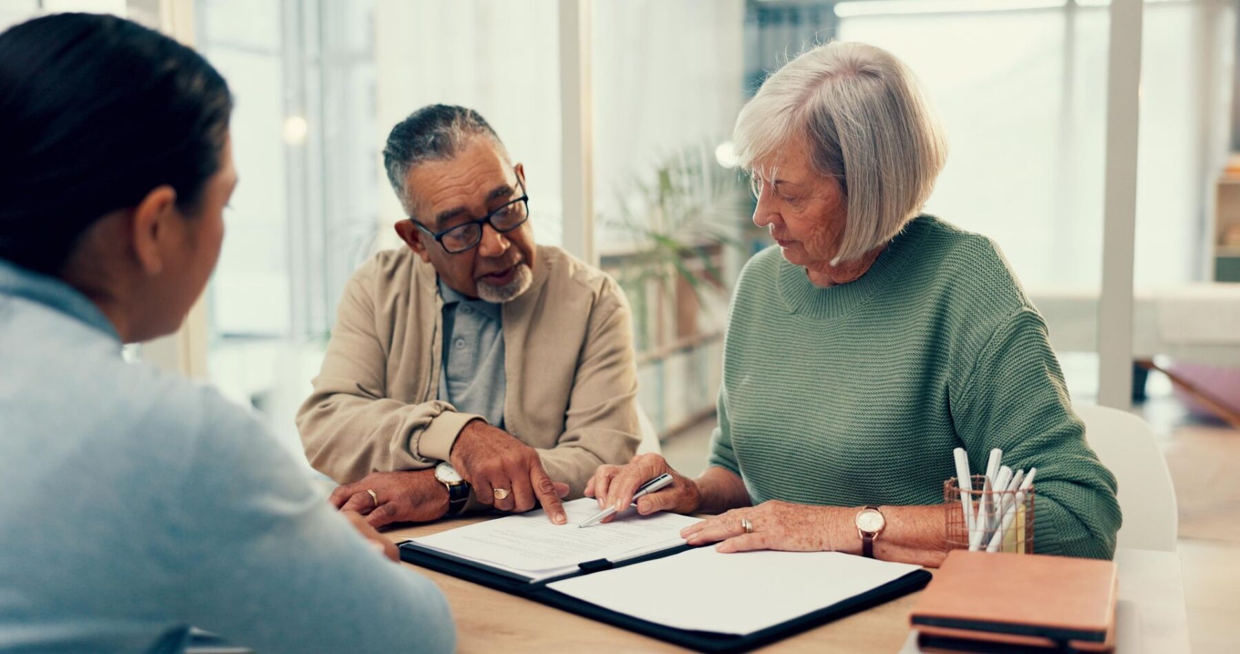 Couple de seniors avec un avocat qui consultent les textes de loi