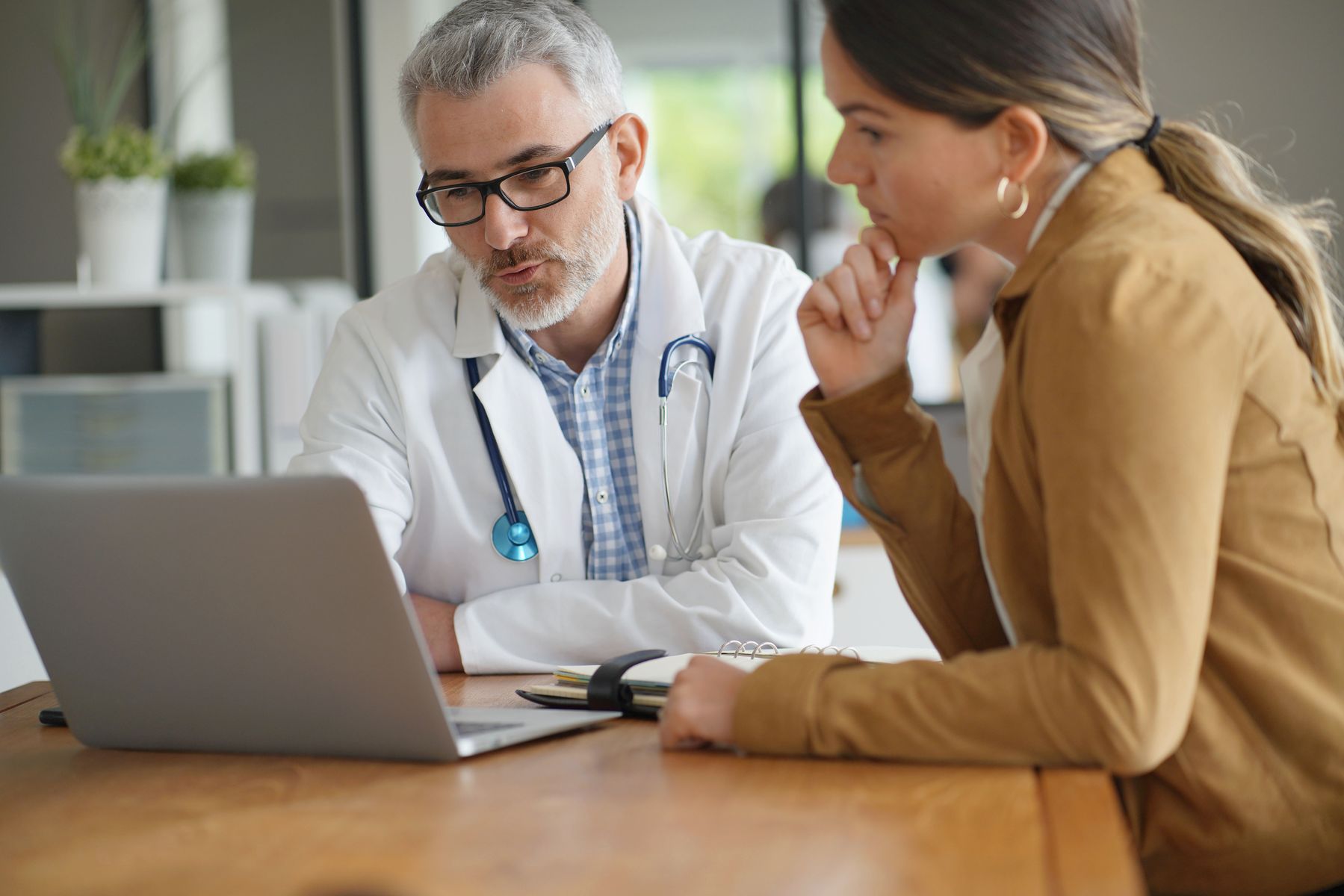 Aidant qui discute avec le médecin pour connaître les perspectives d’évolution de son parent