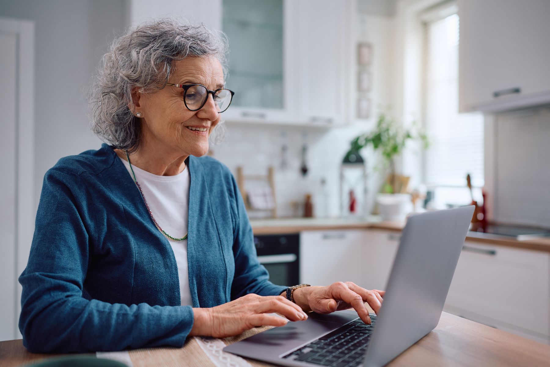 Senior qui regarde et compare les notes des maisons de retraite qui l'intéresse