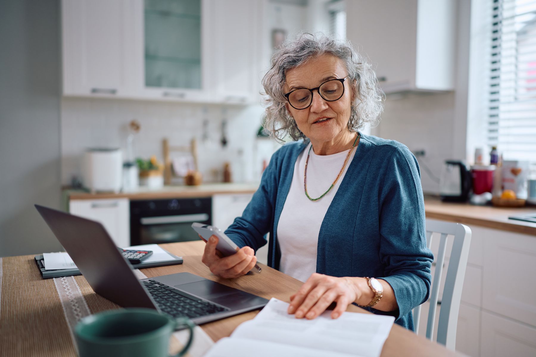 Senior qui calcule le prix d'une maison de retraite autour d'elle