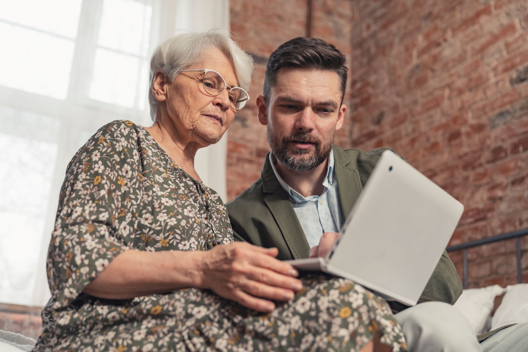 Senior et son aidant qui consultent les frais d’hébergement en EHPAD