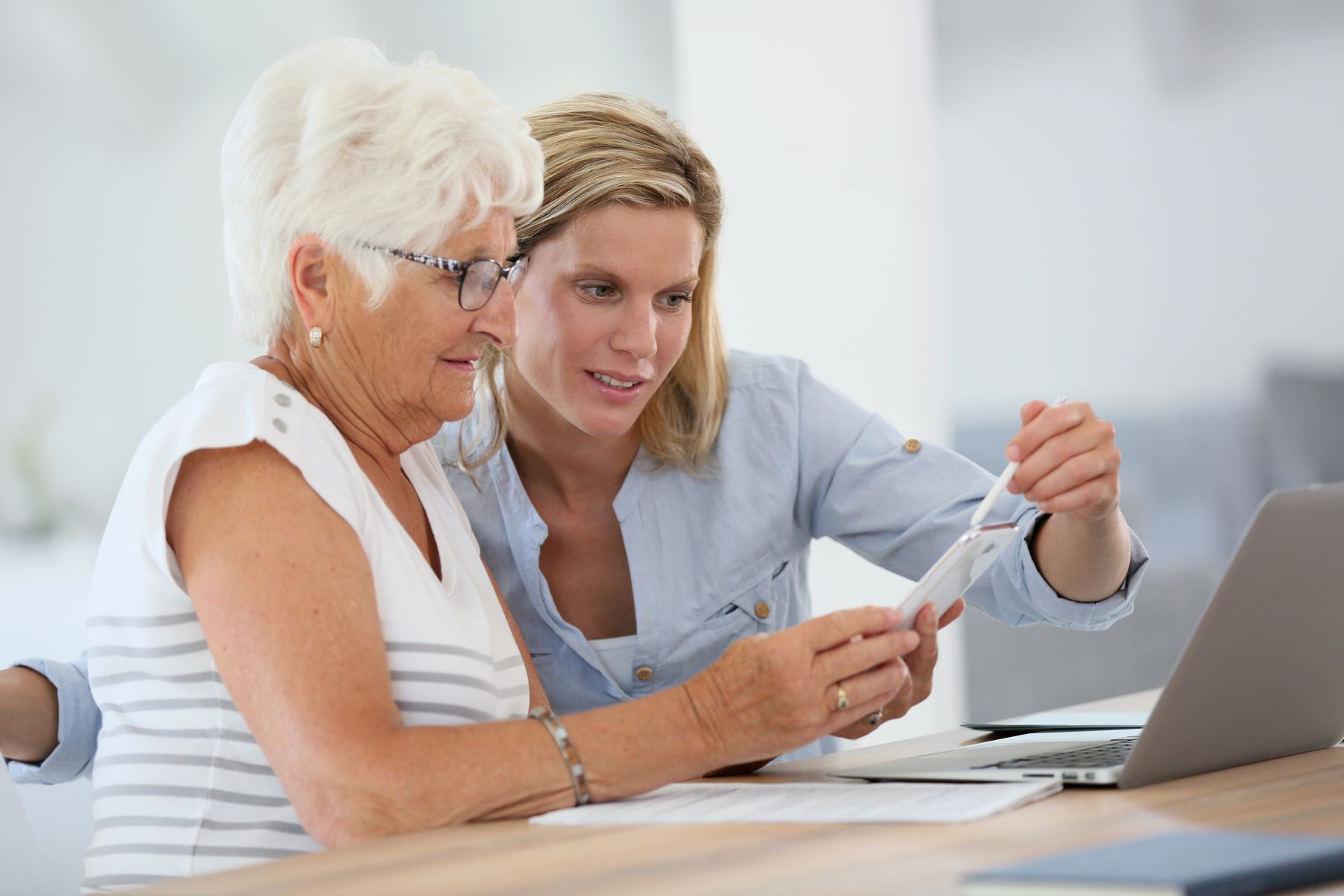 Aidante et sa senior en perte d'autonomie qui se renseignent sur les aides 