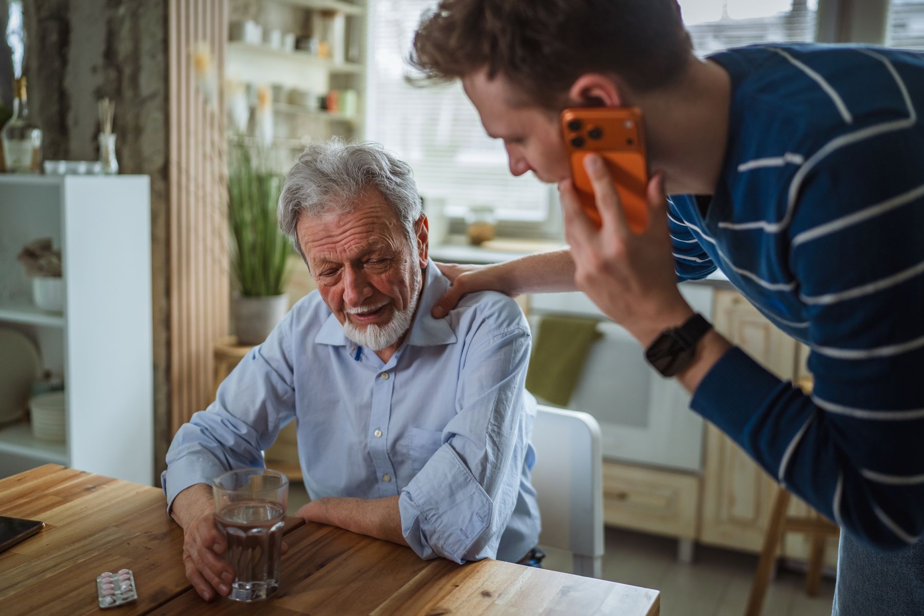 Aidant qui appelle les secours car son proche ressent des douleurs intenses ou des vertiges persistants après la chute